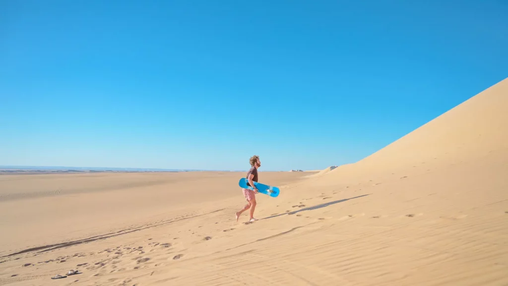 fes desert tour traveler skateboarding in the desert of Merzouga