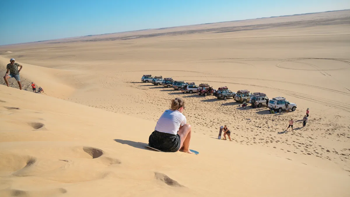 women sandboarding in merzouga sahara desert