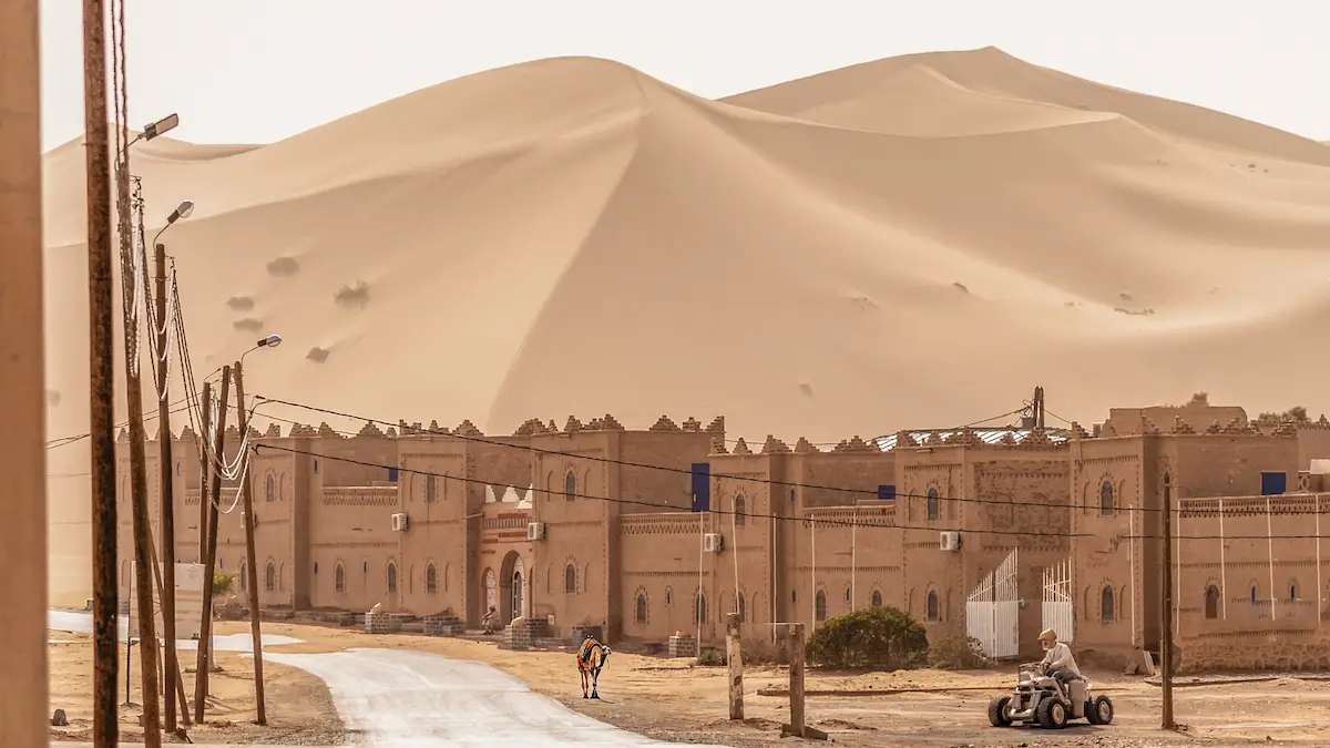 big sand dune behind city of merzouga