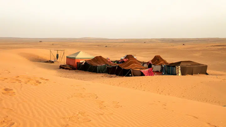 tents of nomads in the middle of the sahara desert of merzouga