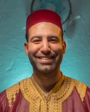 moroccan man with red hat smiling