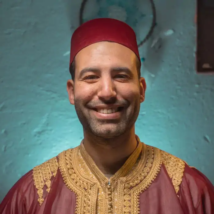 moroccan man with red hat smiling