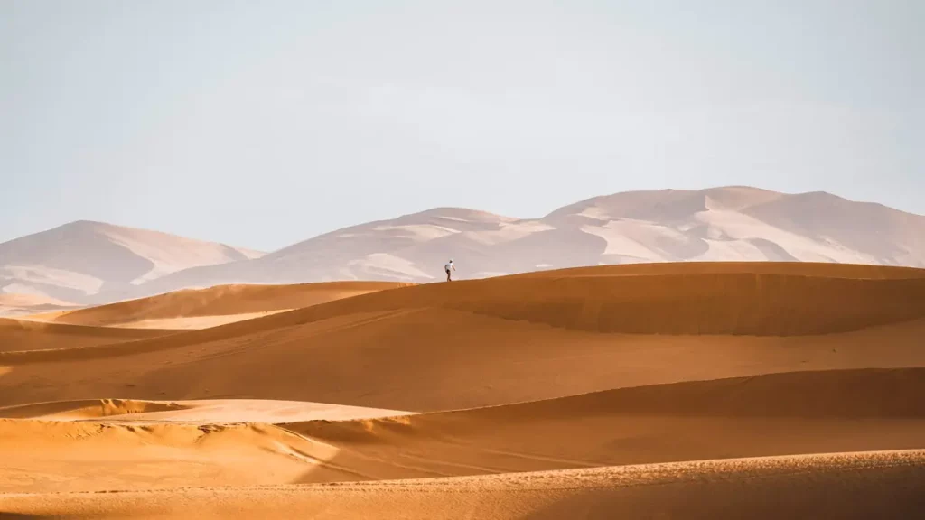 a man alone on a sand dune in the sahara desert morocco]