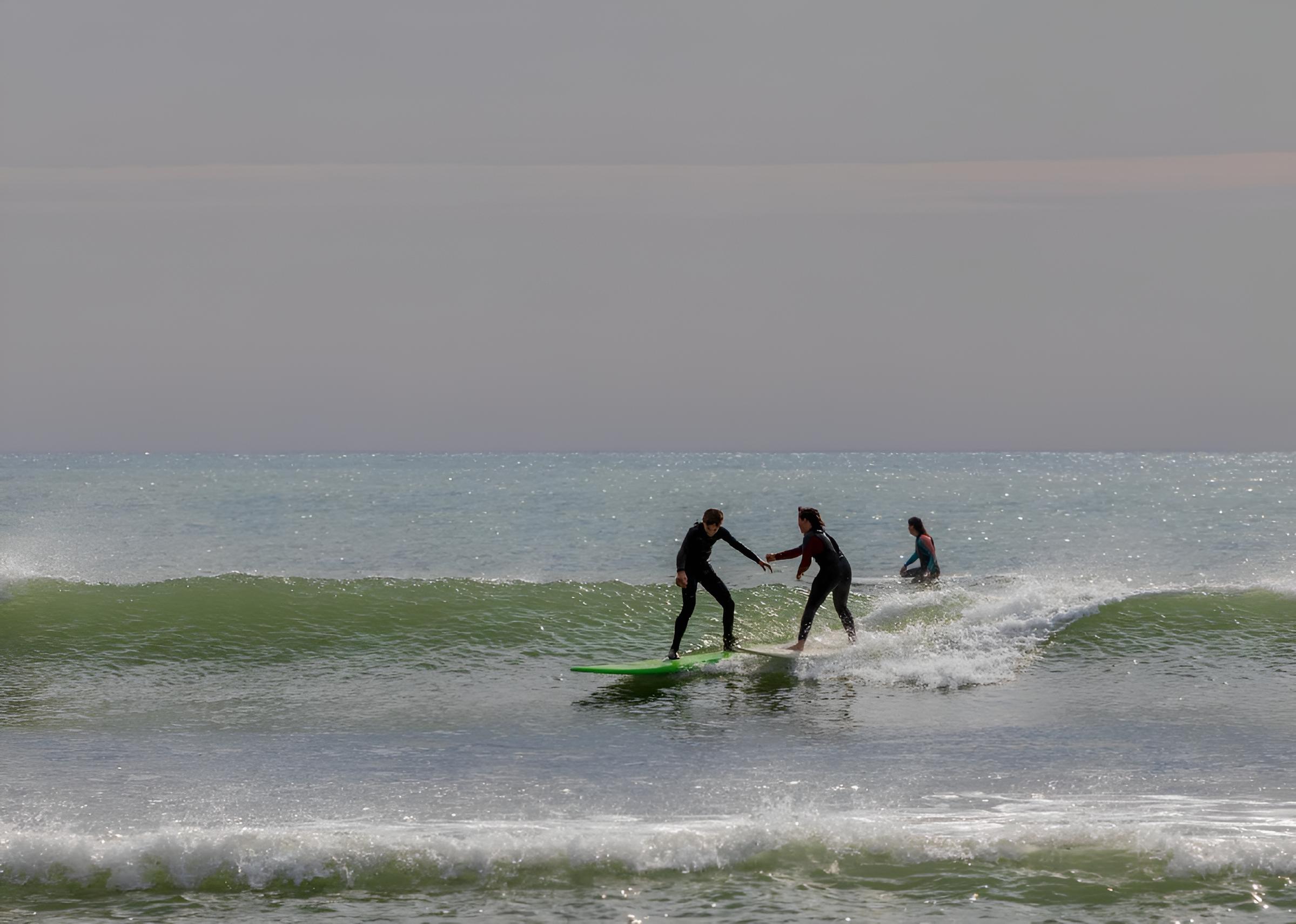 Surfers riding on surfboards on a foamy wave in Casablanca